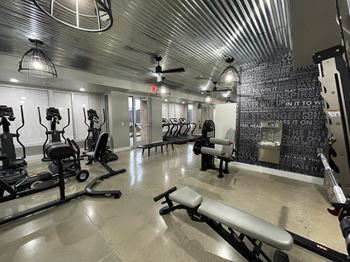 A gym with a variety of equipment including treadmills, weights, and a bench. at 747 Apartments, Indianapolis, Indiana
